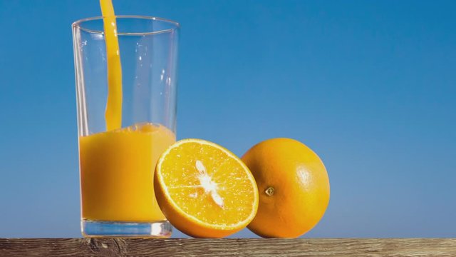pouring a glass of orange juice creating splash