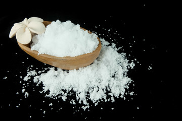 Salt and clay cup on black background.