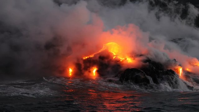 Hawaii Lava ocean close up - Lava running in the ocean from Kilauea volcano, Hawaii. Lava stream seem from lava boat tour flowing from volcanic eruption on Big Island, USA. Dawn Slow motion. Year 2016