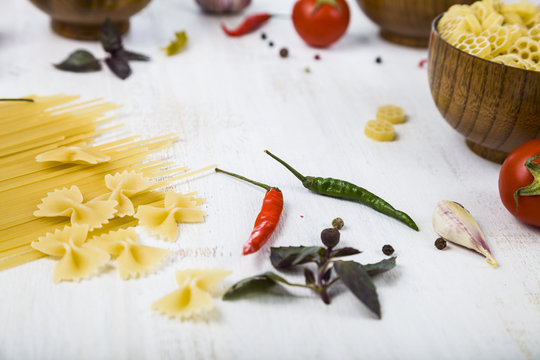 Raw pasta and spices in wooden table. Pasta and ingredients: chi