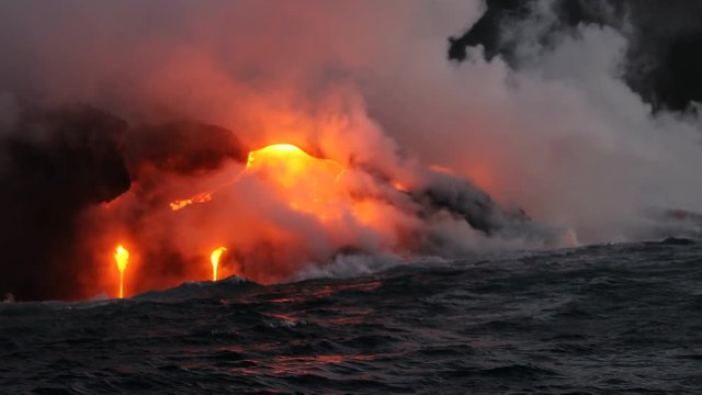 Lava running in the ocean from volcanic lava eruption on Big Island Hawaii. Seen from lava boat tour. Lava from Kilauea volcano by Hawaii volcanoes national park, USA. Dawn, steadicam, 59.94 FPS. 2016