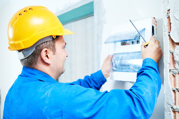 electrician installing switching electric actuator in fuse box