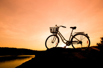 Obraz premium Silhouette of Bicycle with beautiful landscape at sunset or sunrise