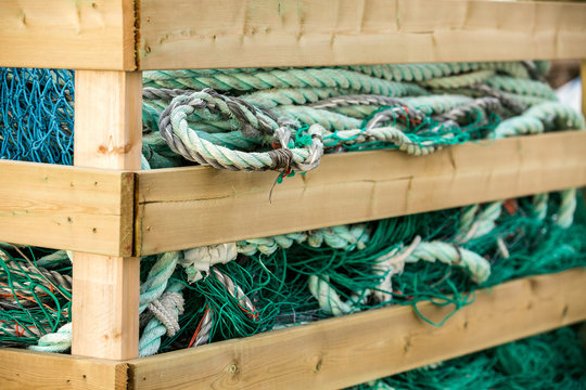 Many fishing nets and floats, stacked on a wooden dock. Fisheries, fishing. Fishing industry.   Background.