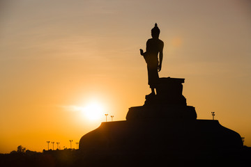 Fototapeta premium Silhouette Of The Posture Of Walking Buddhist Statue In Twilight