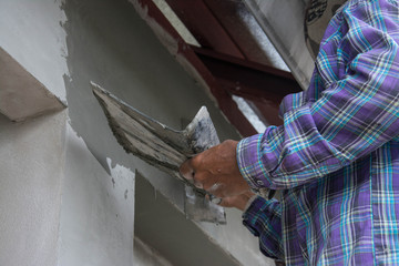 plasterer concrete worker at wall of house construction 