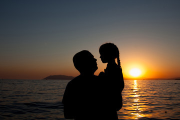 Silhouette of woman and little girl,enjoying and relaxing, on th