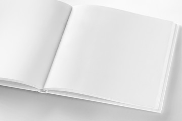 Mockup of opened blank square book at white design paper 
