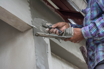 plasterer concrete worker at wall of house construction 
