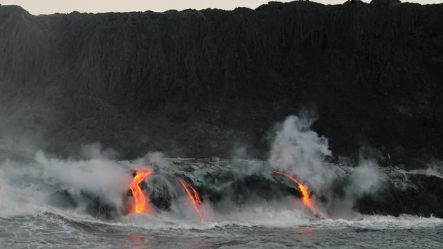 Hawaii Lava flowing into the ocean from lava volcanic eruption on Big Island Hawaii, USA. Lava stream flowing in Pacific Ocean from Kilauea volcano, USA. Seen from water, Steadicam, 59.94 FPS, 2016.