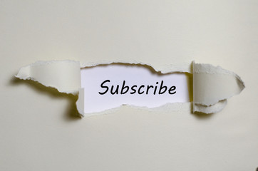 The word subscribe appearing behind torn paper - 127602350