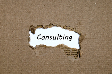 The word consulting appearing behind torn paper