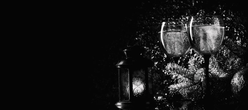 Spruce branches and champagne glasses on a dark background.