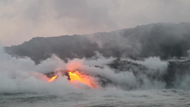 Lava ocean - flowing lava reaching ocean on Big Island, Hawaii. Lava stream seen from the water flowing from Kilauea volcano near Hawaii volcanoes national park, USA. 59.94 FPS, Steadicam. Year 2016.