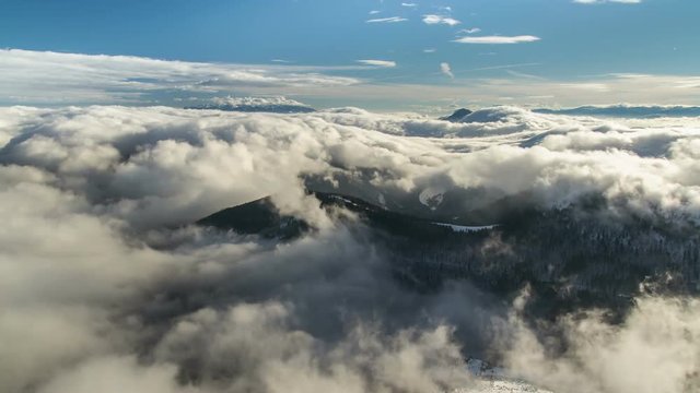 Beautiful waves of low clouds flows in winter mountains time lapse