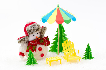 Christmas background, Snowman with sun lounger and beach umbrella.