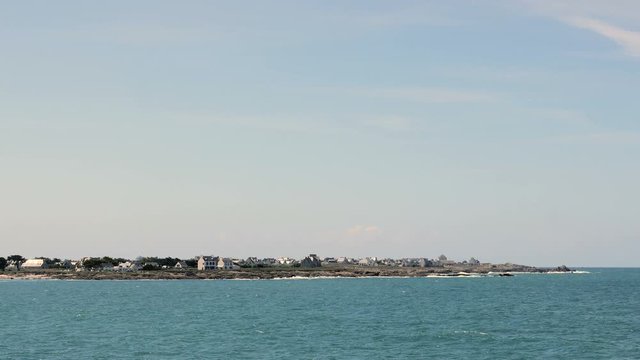 Village on peninsula with ocean in foreground shot from Pointe de la Torche in Brittany, France. Wide shot.