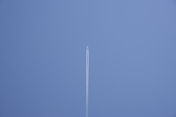 Jumbo Jet zieht weisse Kondensstreifen vor blauem Himmel