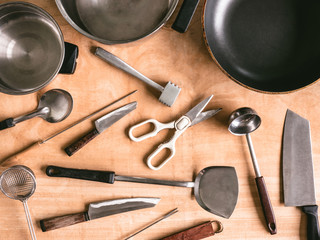 Kitchen utensils on wooden table background.