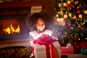 Happy girl looking in open magic Christmas present