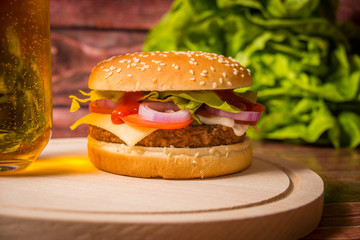 Hamburger and beer on wooden board