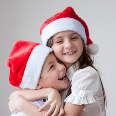 smiling kids in Santa hats hugging