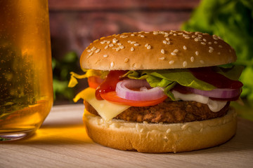 Hamburger and beer on wooden board