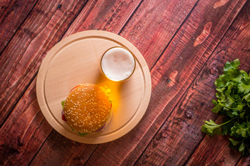 Hamburger and beer on wooden board