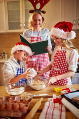 Mother helping kids at making Christmas cookies.