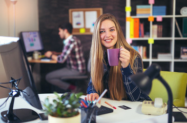 Two young people working on their computers, focus on the woman