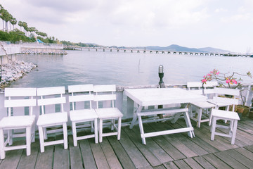 Terrace sea view with outdoor wood chairs and table. Vintage color

