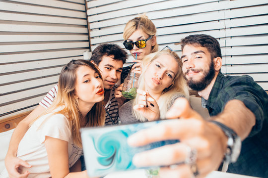 Group of friends making selfie at cafe 