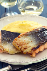 fried salmon on white dish on blue wooden background