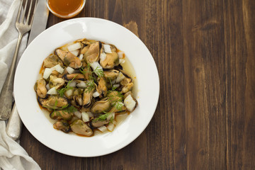 salad mussels with onion in sauce in white plate