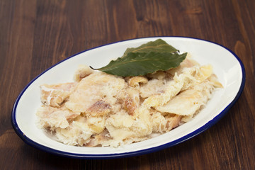 dry cod fish on dish on wooden background