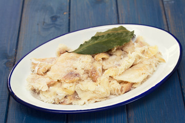 dry cod fish on dish on wooden background