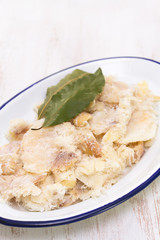 dry cod fish on dish on wooden background