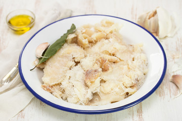 dry cod fish on dish on wooden background