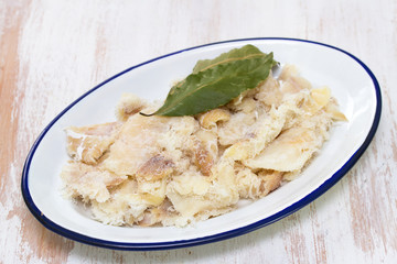 dry cod fish on dish on wooden background