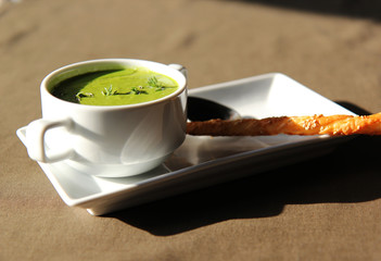green cream soup of celery with cracker
