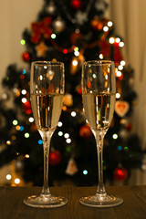 Бокалы с шампанским на фоне рождественской ёлки