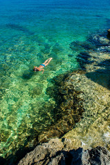 Fototapeta na wymiar Junges Mädchen Schnorchelt durch Türkises Wasser an der Küste