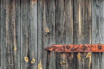 On weathered wooden door old rusty hinge