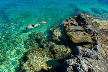 Schöne Frau im Bikini Schnorchelt durch Türkises Wasser an der Küste