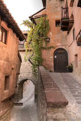 Fototapeta na wymiar Calle de un pueblo antiguo español con un arco y una puerta