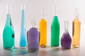 garrafas e copos coloridos em fundo branco