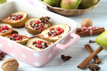 Baked pears with honey, walnuts and cranberries on white wooden
