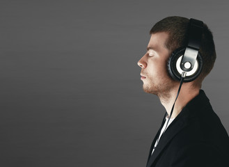 Relax and listening music concept. European man fill the bit. Portrait of head in headphones with closed eyes. Boy in casual wear.