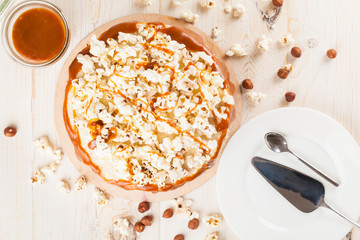 Homemade cake with hazelnuts and salty caramel with vanilla - hazel shortcakes and delicate hazelnut cream, decorated with salty popcorn. Top view.