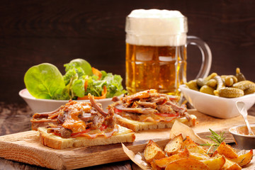 Sandwich with shredded pork, roasted potatoes and salad